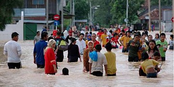 Afbeelding: Maleisiërs op de vlucht voor het water."