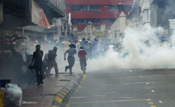 Afbeelding: Demonstranten rennen weg voor traangas in de straten van Kuala Lumpur"